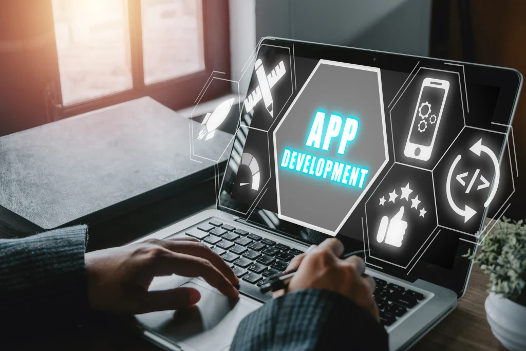 Person typing on a laptop displaying the text "App Development" surrounded by digital icons, conveying a tech and innovation theme. Mint Digital Solutions