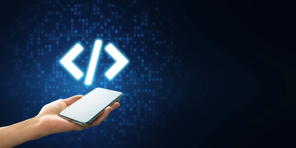 A hand holds a smartphone with glowing coding symbols (angle brackets) above it against a digital blue background, conveying technology and innovation. mint digital solutions
