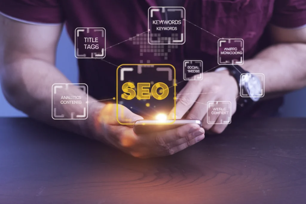A person taps a smartphone, with digital icons illustrating SEO concepts like keywords, analytics, and social media, glowing above the device. mintdigitalsolutions